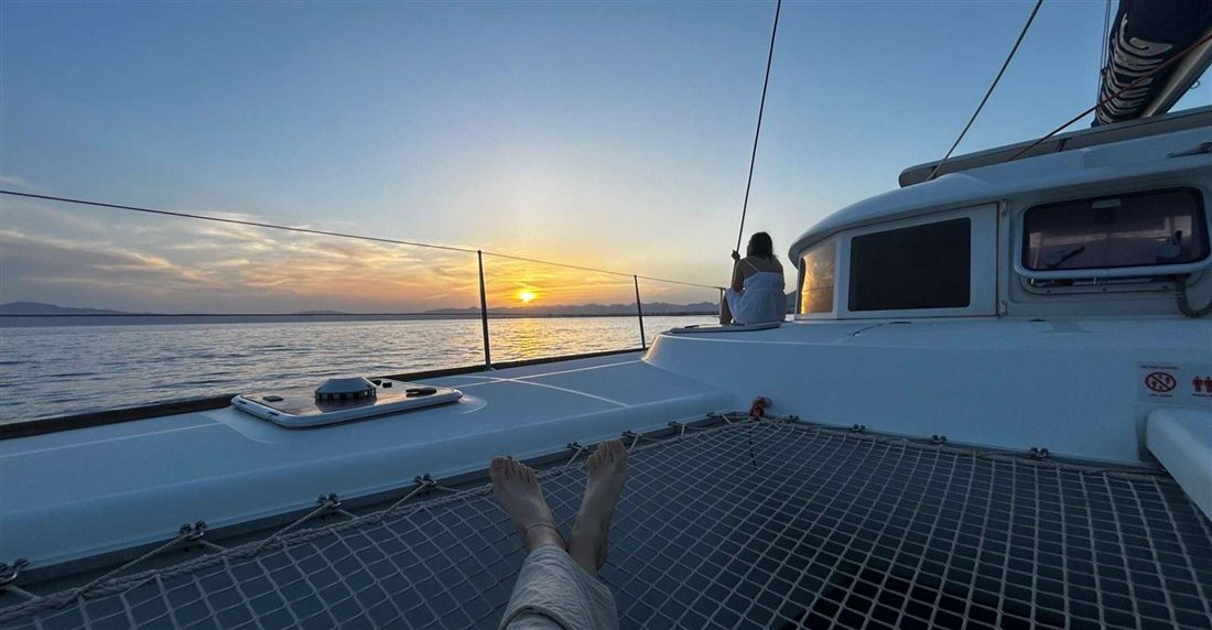 The trampoline net and deck of a catamaran in the low evening sun on the Messenian Gulf