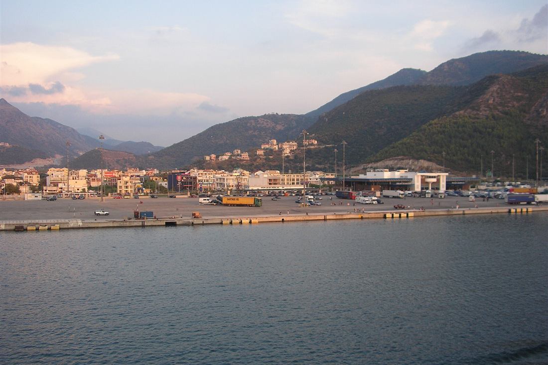 Igoumenitsa port quay with trucks and the harbour terminal below green mountains
