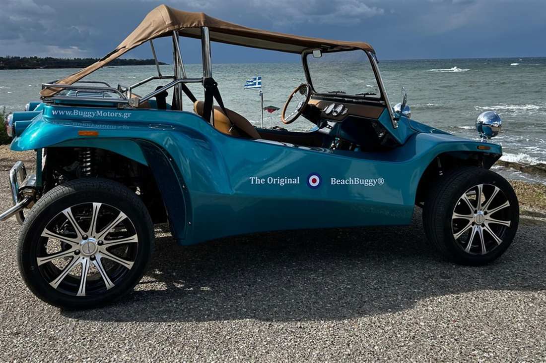 A turquoise beach buggy parked on the coast road above the sea, the open car used on a Katakolo buggy tour.