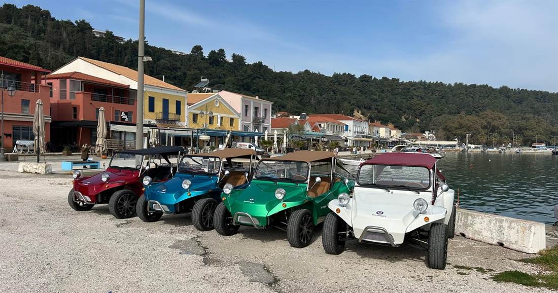 A row of coloured beach buggies lined up on the harbour front, the meeting point of a Katakolo buggy tour.