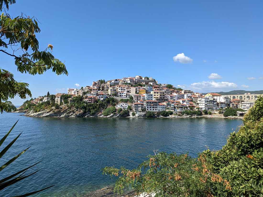 The Panagia old town of Kavala rising on its peninsula above the blue sea under a clear sky