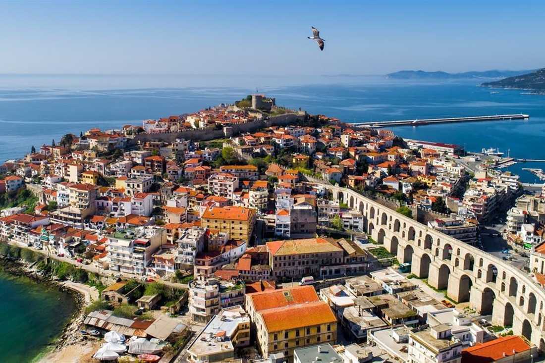 The old town of Kavala on its peninsula, with the castle on top, the harbour and the long stone aqueduct, seen from above on a Kavala private tour.