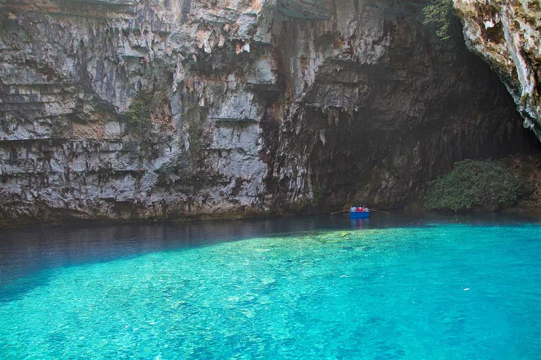 Turquoise water under the rock walls of the Melissani cave lake on Kefalonia, a stop on a Kefalonia bus tour.