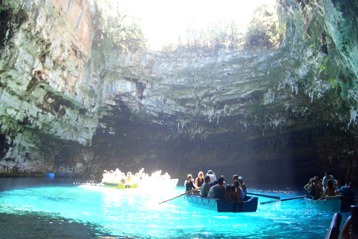 Rowing boats on the turquoise Melissani cave lake, a stop on a Kefalonia day trip from Zakynthos