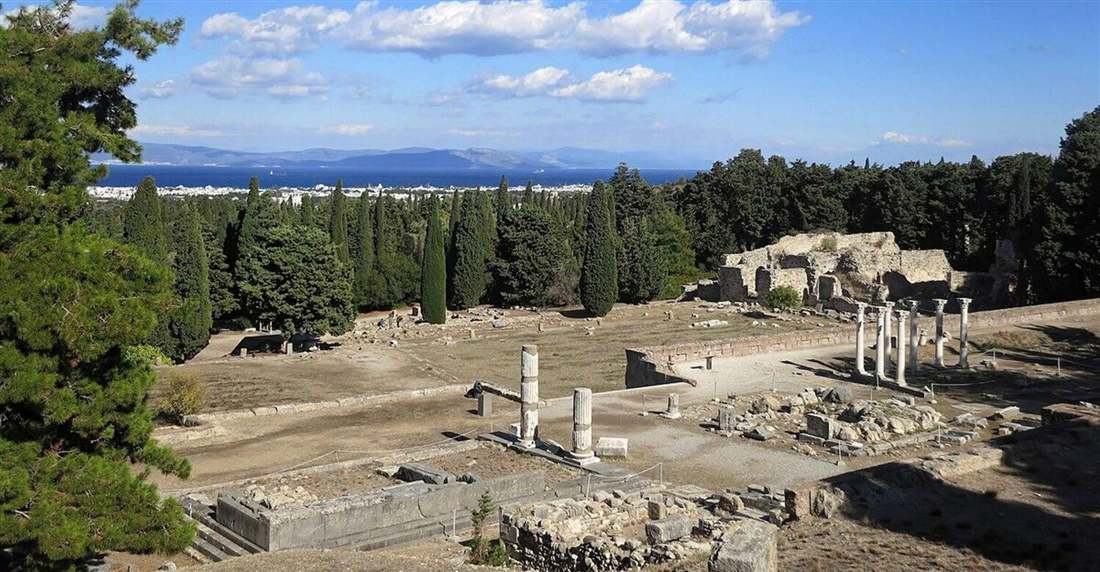 The terraces and standing columns of the Asklepieion of Kos among cypress trees, with the town and the sea below