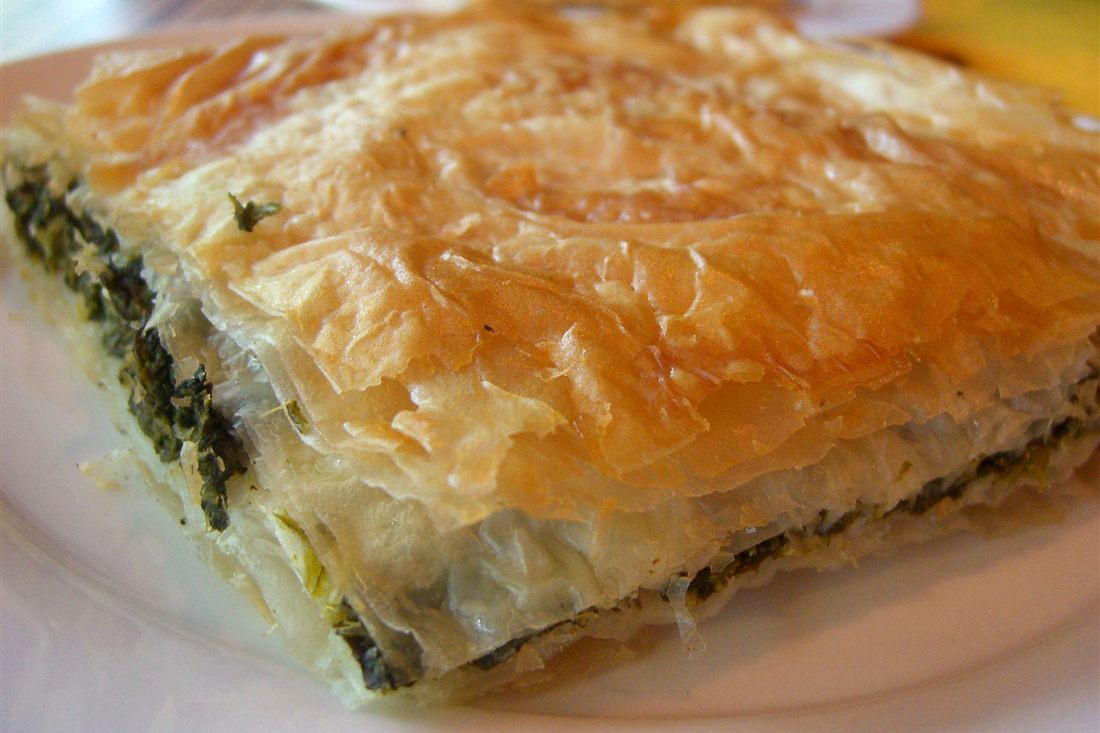 A golden spanakopita, a Greek spinach pie wrapped in phyllo pastry, the kind of pie baked in a Lefkada cooking class.