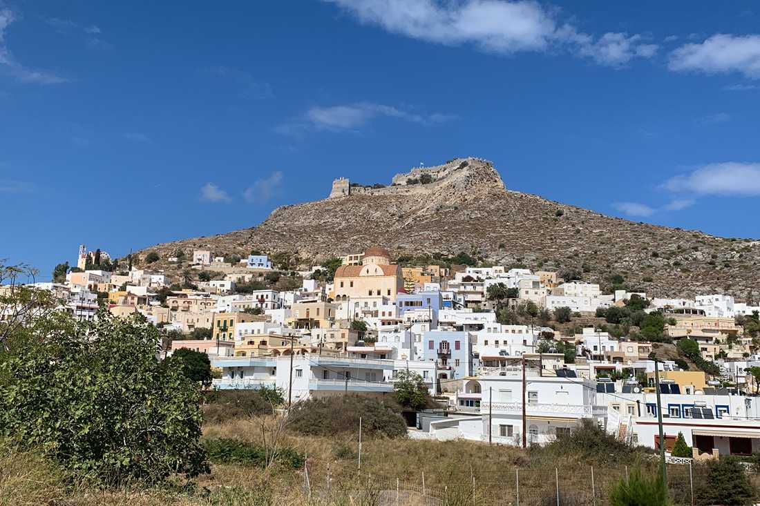 Hillside houses of Platanos in Leros below the castle on the ridge under a blue sky