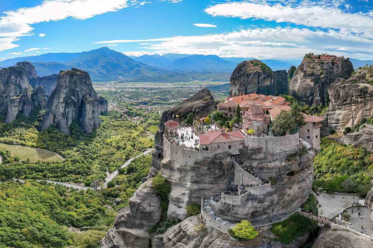 Varlaam Monastery on its rock pillar with the Great Meteoron on the rock behind, two sites visitors enter with Meteora monasteries tickets