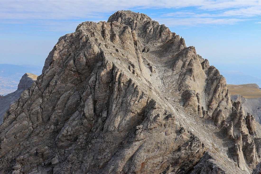 The bare rocky summit ridge of Mount Olympus under a blue sky, the goal of a Mount Olympus day trip from Athens.