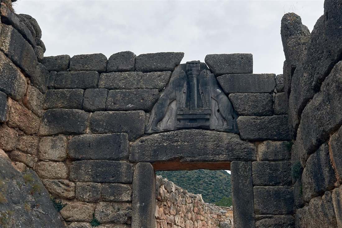 The Lion Gate of Mycenae, a carved relief of two lions above a stone lintel in walls of huge blocks.