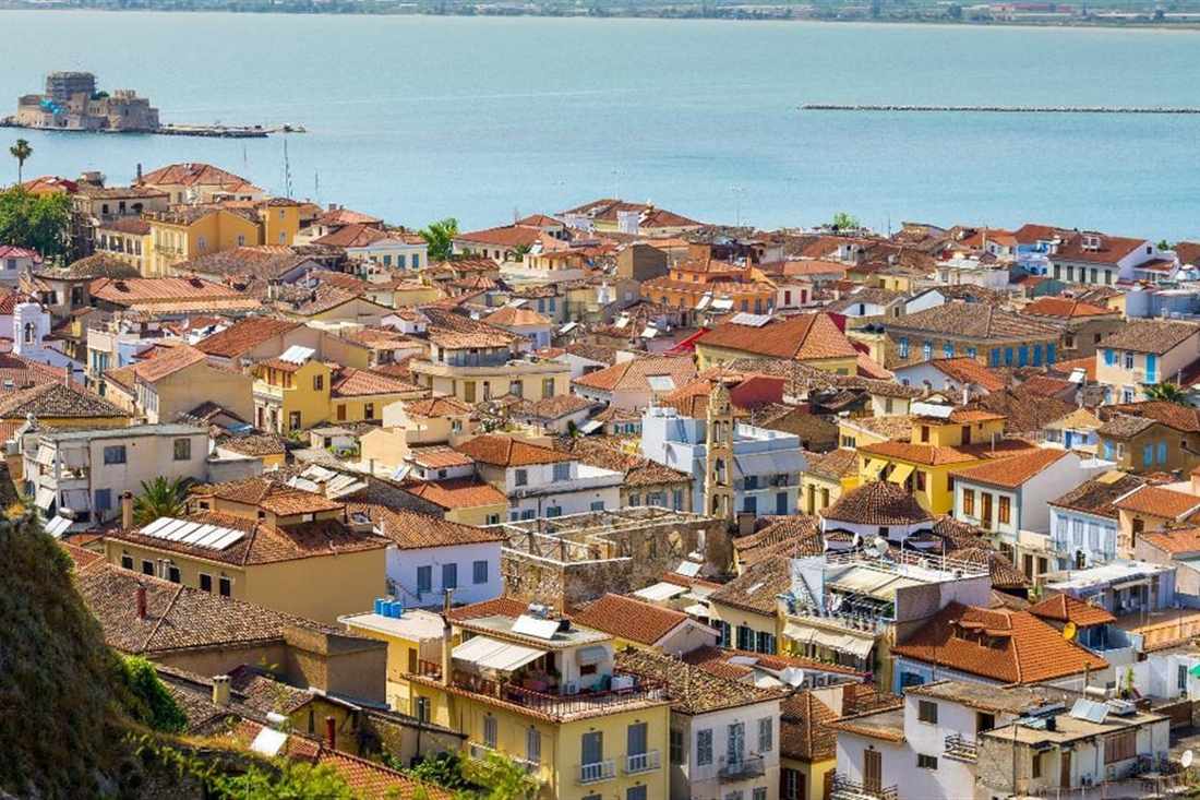 The red roofs of the old town of Nafplio and the Bourtzi castle in the bay, the town a Nafplio hop on hop off bus tours.
