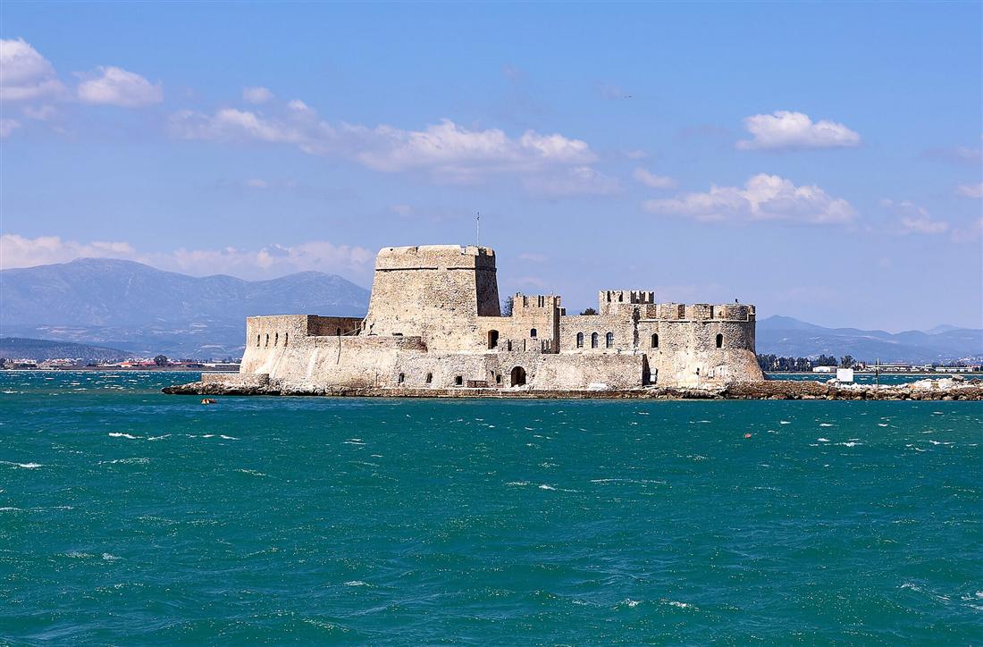 The Bourtzi castle on its islet in the harbour of Nafplio under a blue sky