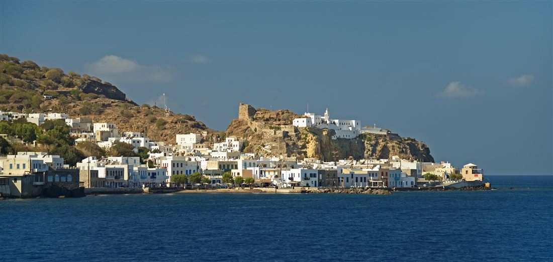 The white houses of Mandraki below the Knights' castle and the Panagia Spiliani monastery seen from the sea, the arrival on a Nisyros boat trip.