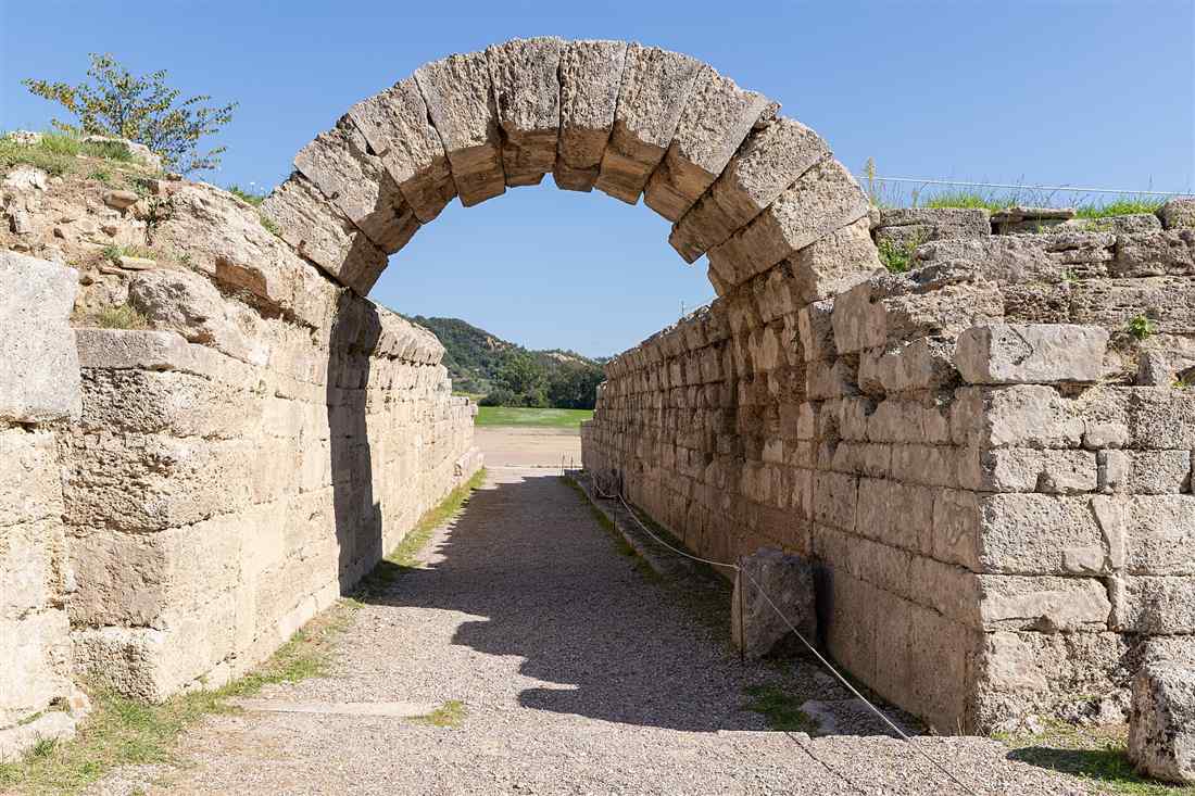 The arched stone tunnel of the Krypte leading into the ancient stadium of Olympia, the entrance groups walk through on an Olympia shore excursion.