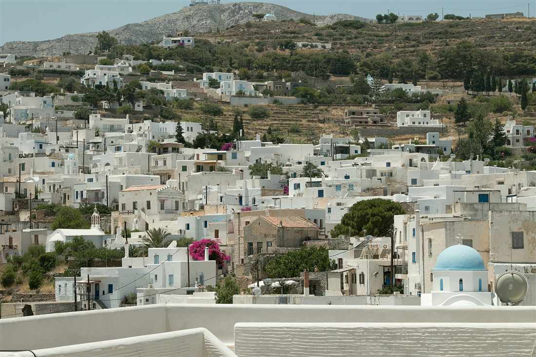 The white houses of Lefkes spread across the green hillside in the centre of Paros, a mountain village on a Paros bus tour.