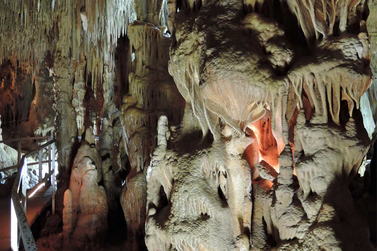Stalagmite columns and stalactites line the visitor walkway on the guided tour included with Petralona Cave tickets.