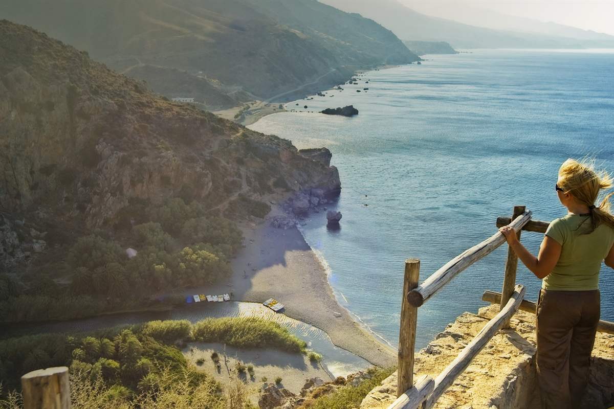 A visitor at the viewpoint above Preveli beach, the river lagoon and the Libyan Sea, the goal of a Preveli day trip from Heraklion