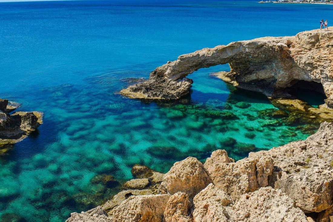 Natural rock arch over clear turquoise water on the Cape Greco coast near Ayia Napa