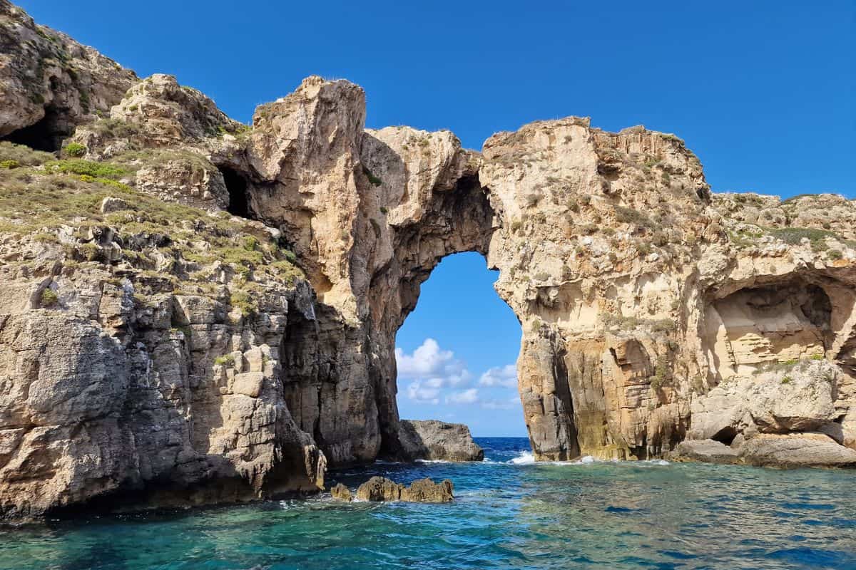 Pylos tours by boat reach the Tripito rock arch on the Tsichli Baba islet in Navarino Bay