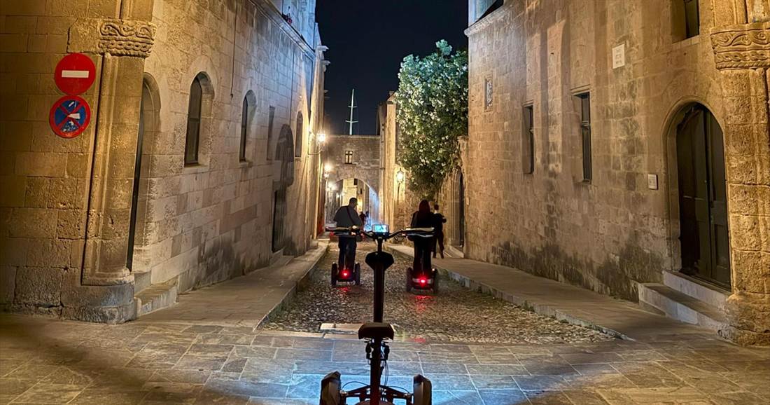 Segways with their lights on along the cobbled Street of the Knights in Rhodes at night, on the night route of a Rhodes segway tour.