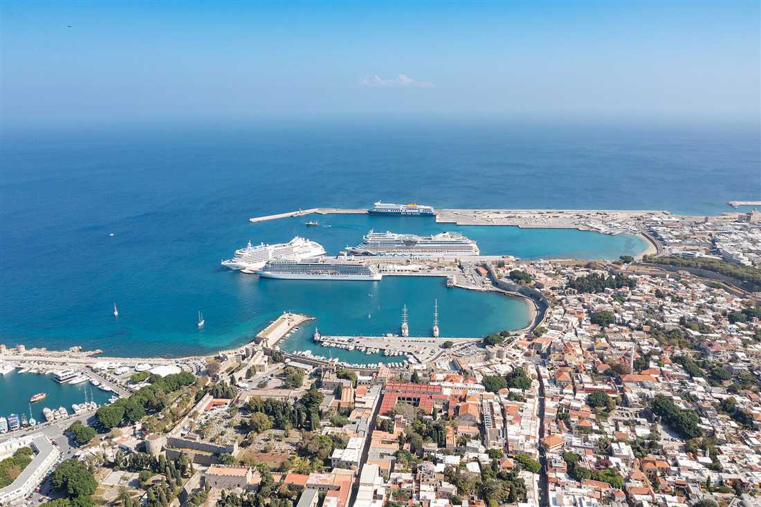 Cruise ships berthed in the harbour of Rhodes town beside the walled medieval Old Town, where a Rhodes shore excursion starts.
