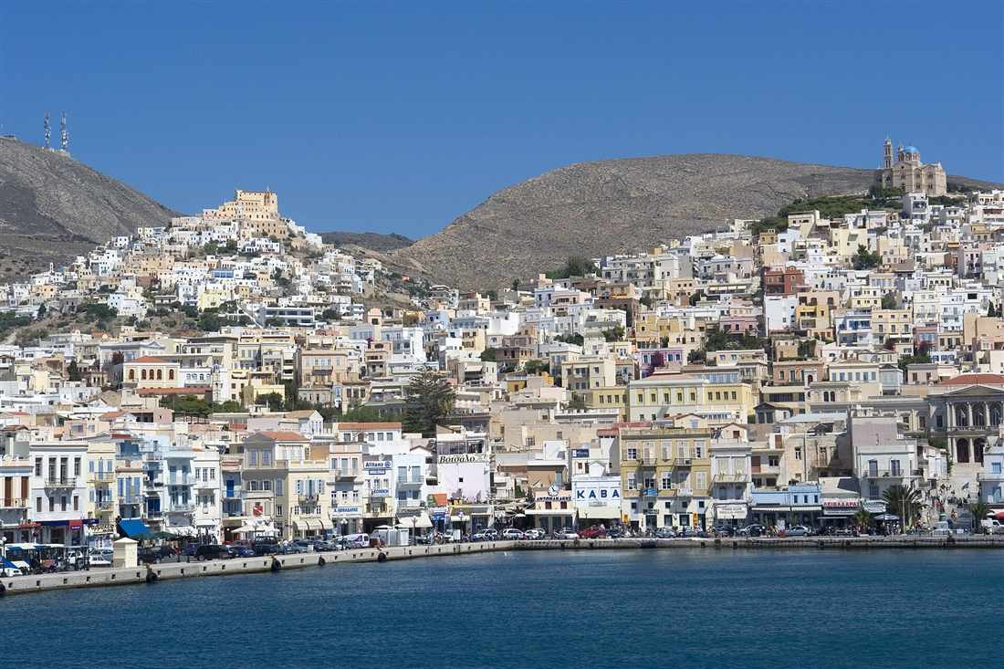 Ermoupoli rising from the harbour of Syros to the hills of Ano Syros and Anastasi under a clear blue sky