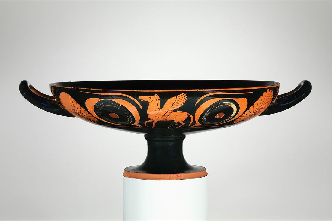 Ancient Greek terracotta kylix, a wide two-handled wine drinking cup, with a winged horse between two large eyes on the bowl