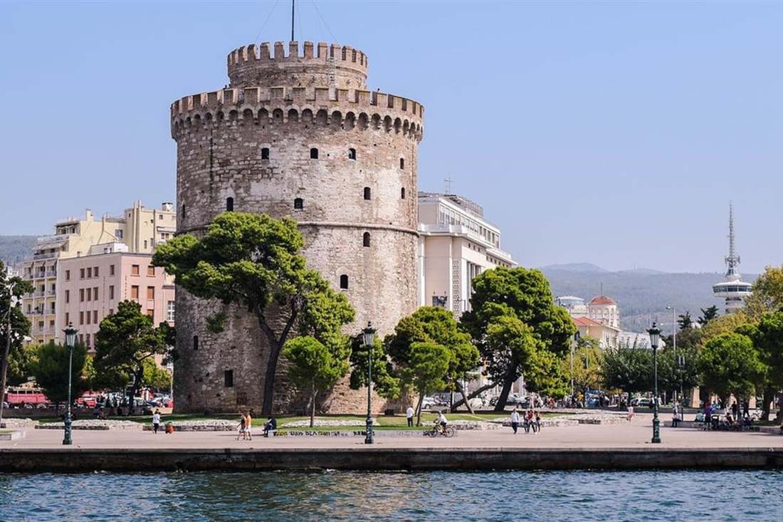 The White Tower beside the waterfront promenade of Thessaloniki under a blue sky, a stop on a Thessaloniki shore excursion.