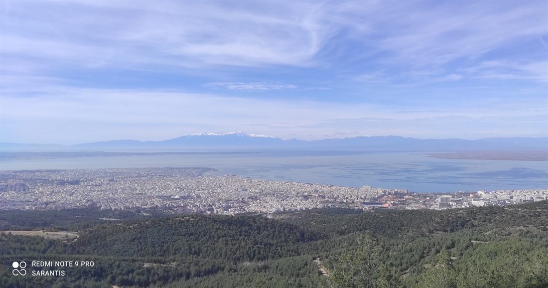 Forested hills fall away to a wide view of Thessaloniki and the Thermaic Gulf, with mountains on the far horizon, on a Thessaloniki traditional villages tour.