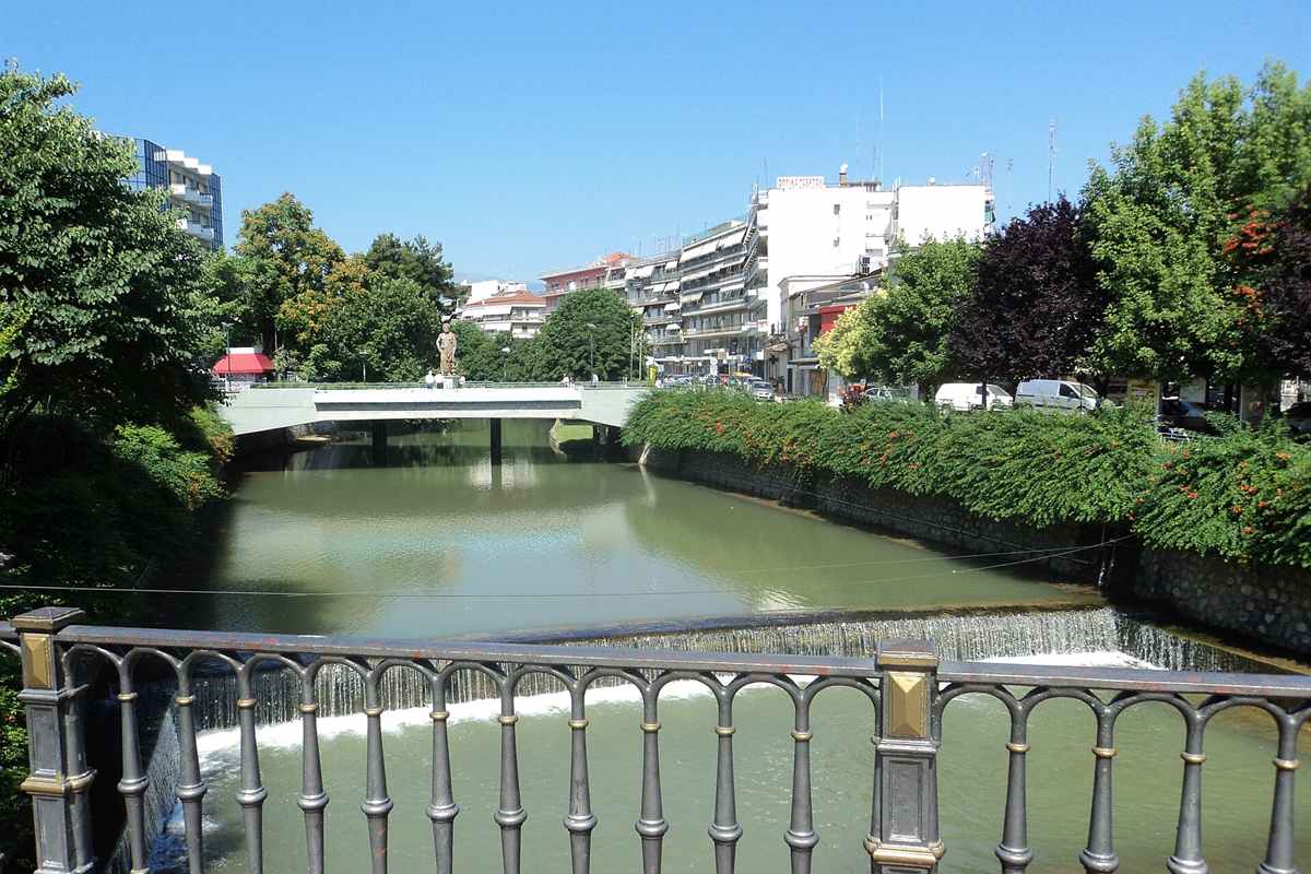 Trikala tours along the Lithaios river with the bridge and the statue of Asclepius in Trikala town