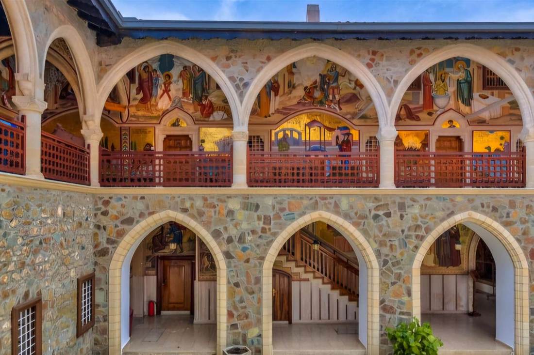 Frescoed arcades and stone arches in the courtyard of Kykkos Monastery in the Troodos Mountains