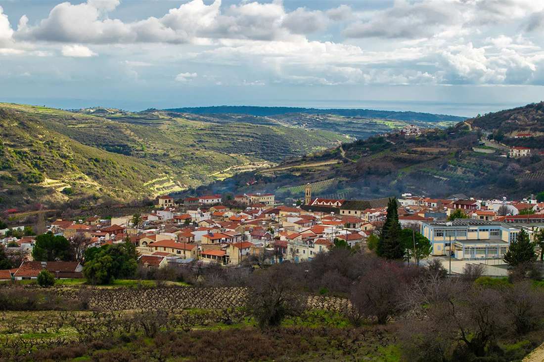 A wine village with red-tiled roofs among vineyards and terraced hills in the Troodos foothills of Cyprus