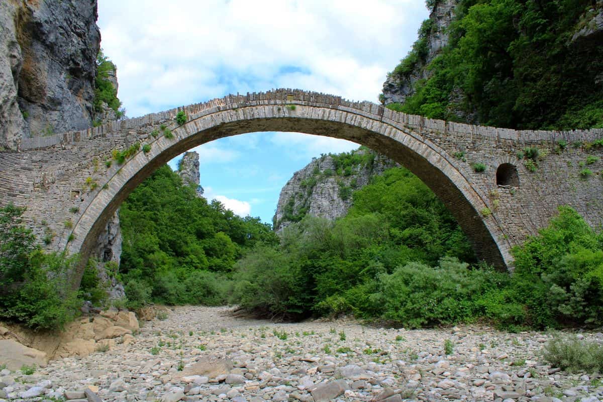 Zagori tours at the single-arch stone bridge of Kokkoris over the Voidomatis riverbed