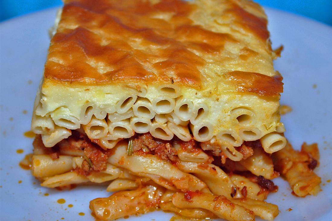 A slice of pastitsio, baked pasta with minced meat under a creamy golden top, a Greek oven dish taught in a Zakynthos cooking class.