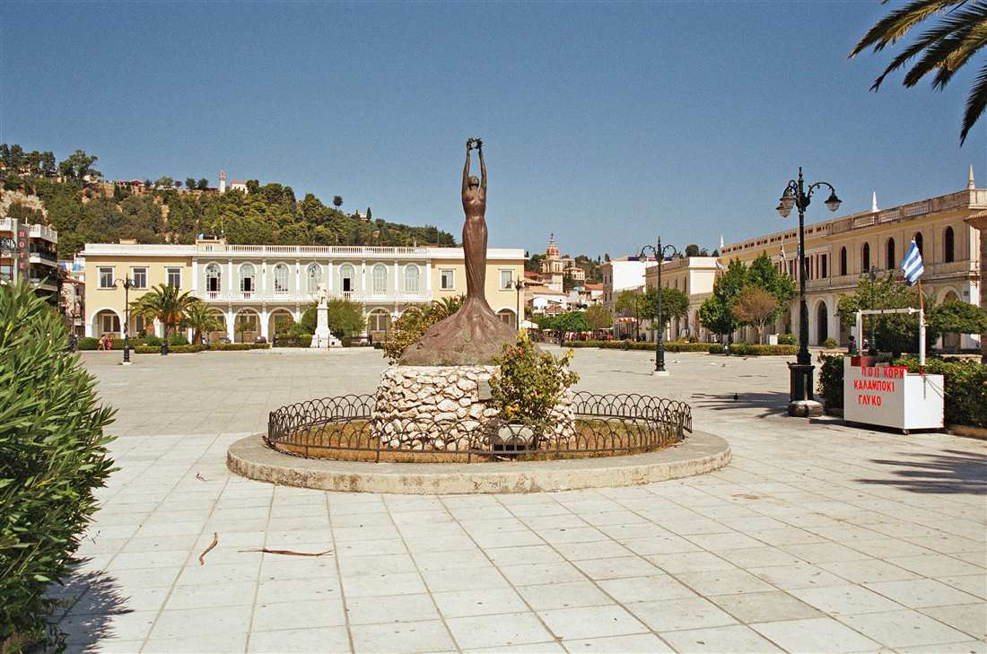 Solomos Square in Zakynthos Town with the statue of the poet and the arcaded buildings, a stop on a Zakynthos shore excursion from the port.
